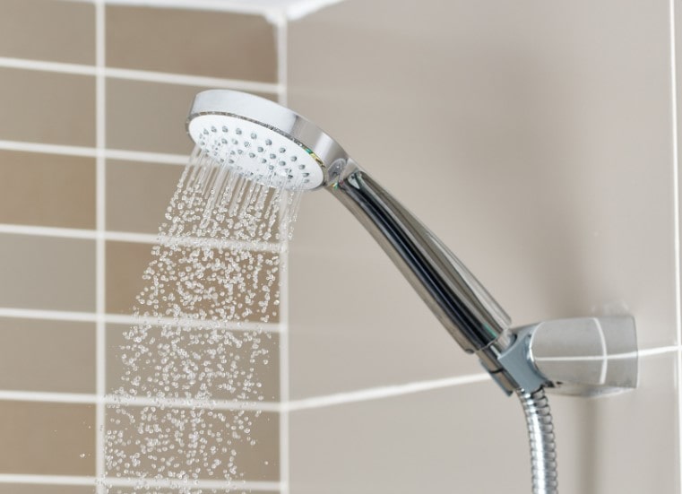 Water running from a shower head in a Self-Contained Shower Pod.