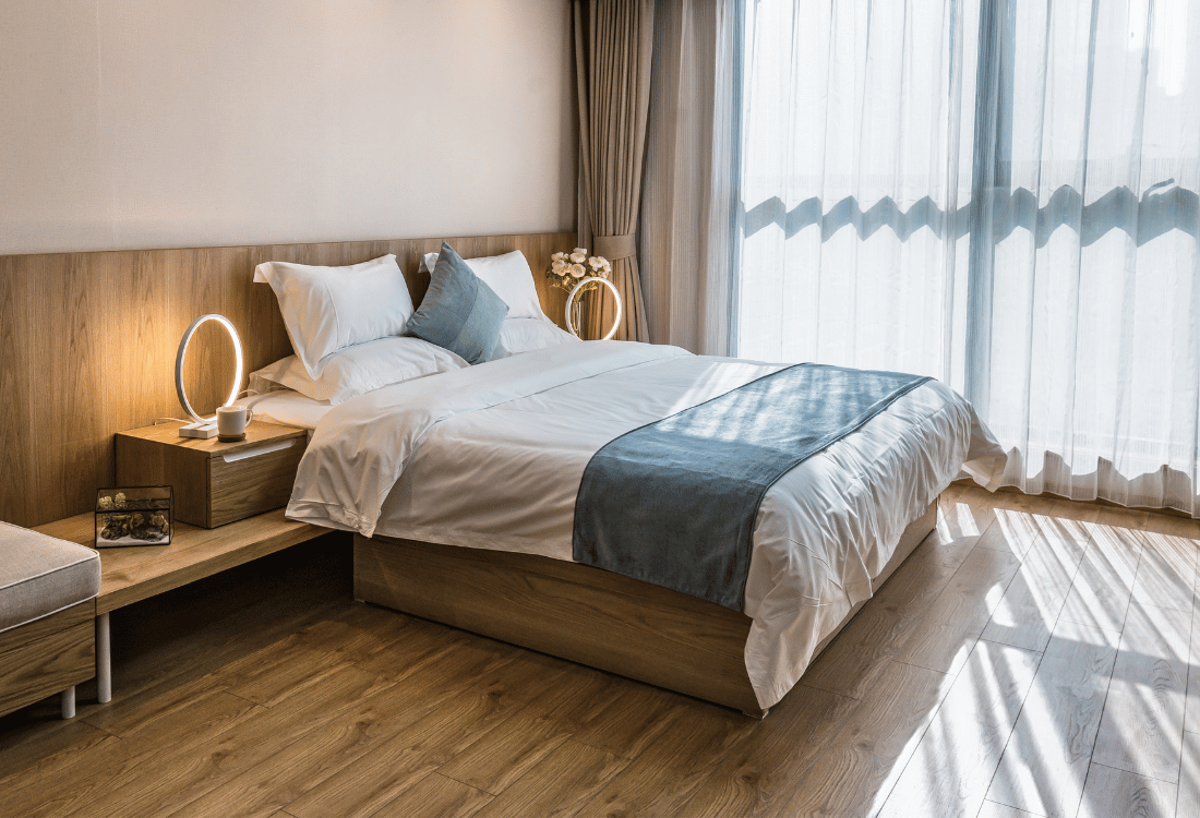 A nicely decorated bedroom in a HMO next to a bathroom with a shower pod.