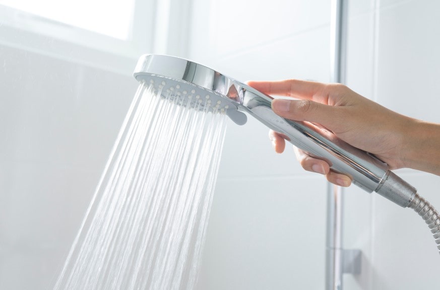 Mould free shower head in shower as the homeowner has incorporated heating, humidstats and high ventilation in their bathroom