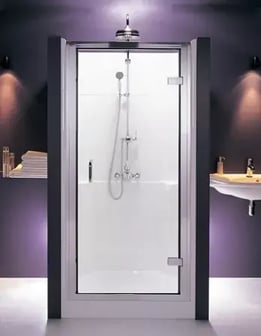 A shower pod in a purple bathroom with lights above.