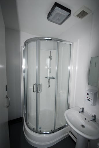 Modern white Sustainable Shower enclosure with easy-clean wall panels and low-maintenance bathroom design.