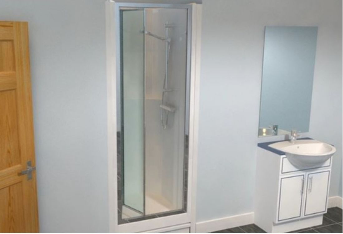 An illustration of a sink with a glass shower area next to it.