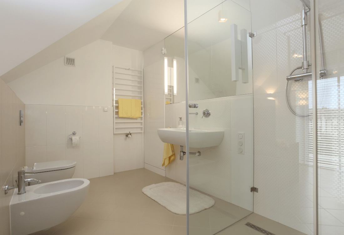 Pristine white bathroom with glass shower cubicle, exemplifying how to prevent mould in the home.