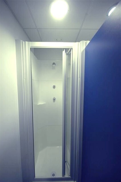 Clean shower pods with compact enclosed design and spotless white interior in a modern bathroom setting.